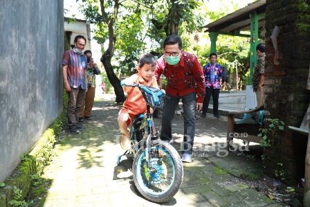 Achmad Rizal Kurdianto ssat menaiki hadiah sepeda dari Bupati Sidoarjo (22/02) (IST)