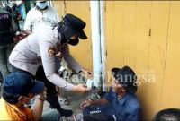 Polwan Polres Bangakalan saat memakaikan masker (IST)