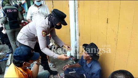 Polwan Polres Bangakalan saat memakaikan masker (IST)