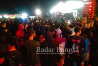 Kapolsek Ngimbang AKP Sampun saat melakukan pengamanan dilokasi kejadian dan tampak ratusan massa melakukan blokade jalan di simpang tiga MPU terminal Ngimbang.(IST)