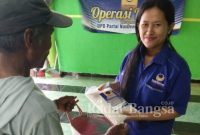 Ratih Puspita Sari, Sekretaris DPC Partai NasDem Kecamatan Kayen Kidul, memberikan paket beras premium kepada warga 