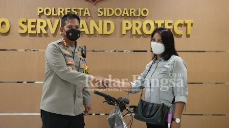 Kapolresta Sidoarjo Kombes Pol. Kusumo Wahyu Bintoro, saat menyerahkan hadiah satu unit sepeda MTB Polygon kepada Farida di Mapolresta Sidoarjo, Jumat (29/4/2022) (IST)