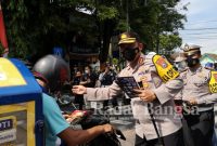 Kapolres AKBP. Dewa Putu Eka D., S.I.K., M.H 
saat  membagikan blosur dan memberi penjelasan langsung tentang giat operasi tersebut kepada pengendara yang melintas. (Dok Foto Humas)