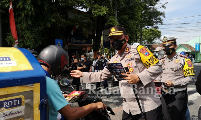 Kapolres AKBP. Dewa Putu Eka D., S.I.K., M.H 
saat  membagikan blosur dan memberi penjelasan langsung tentang giat operasi tersebut kepada pengendara yang melintas. (Dok Foto Humas)