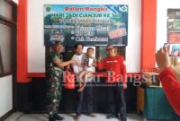  Danramil Cidaun Kapten Kav. M. Ma'rufin di dampingi Kepala Puskesmas Rawat Inap Cidaun H. Eman Sulaeman. S. Kep sedang menyerahkan paket hiburan buat anak-anak yang telah selesai khitanan di puskesmas rawat inap Cidaun. (Dok photo AE Nasution/RadarBangsa.co.id)