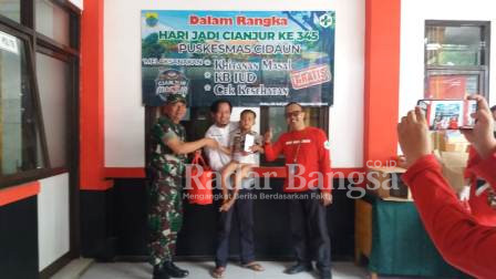  Danramil Cidaun Kapten Kav. M. Ma'rufin di dampingi Kepala Puskesmas Rawat Inap Cidaun H. Eman Sulaeman. S. Kep sedang menyerahkan paket hiburan buat anak-anak yang telah selesai khitanan di puskesmas rawat inap Cidaun. (Dok photo AE Nasution/RadarBangsa.co.id)