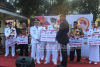 Kapolres Lumajang, didampingi Bupati Lumajang Thoriqul Haq saat memberikan hadiah kepada pemenang Pos Kamling terbaik setelah upacara peringatan hari Bhayangkara ke 76 yang digelar di Alun-Alun Lumajang, Selasa (5/72022). (Dok Foto IST)