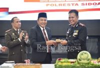  Wakil Bupati Sidoarjo H. Subandi SH saat memberikan potongan kue kepada Kapolresta Sidoarjo Kombes Pol. Kusumo Wahyu Bintoro (Dok Foto IST)