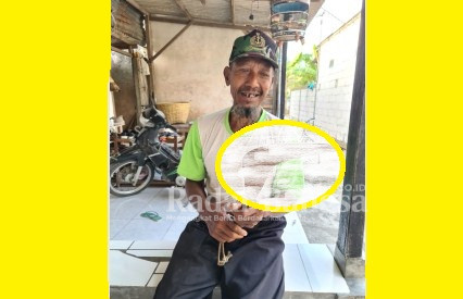 Khosim yang berpropesi penggali kubur dan saat memegang Sabit peninggalan orang tuanya (Dok Foto IST)