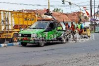  Saat para pekerja melakukan pemadatan jalan yang berlubang