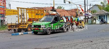  Saat para pekerja melakukan pemadatan jalan yang berlubang