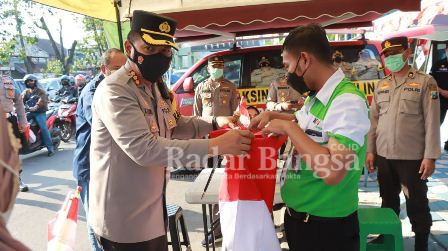 Kapolresta Sidoarjo Kombes Pol. Kusumo Wahyu Bintoro saat bagikan bendera merah putih (IST)