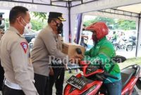 Kapolresta Sidoarjo Kombes Pol. Kusumo Wahyu Bintoro didampingi Kasat Lantas Polresta Sidoarjo Kompol Yanto Mulyanto membagikan paket sembako kepada pengendara ojol di sekitar Taman Pinang Indah Sidoarjo.
