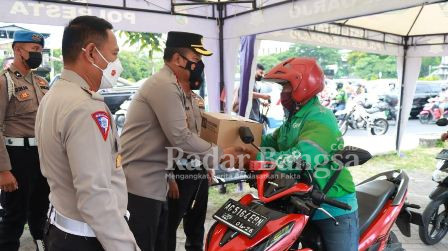 Kapolresta Sidoarjo Kombes Pol. Kusumo Wahyu Bintoro didampingi Kasat Lantas Polresta Sidoarjo Kompol Yanto Mulyanto membagikan paket sembako kepada pengendara ojol di sekitar Taman Pinang Indah Sidoarjo.
