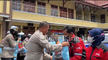 Kapolres Lumajang AKBP Dewa Putu Eka Darmawan. S.I.K., M.H membagikan bantuan sembako secara simbolis.