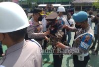 Kapolres Purworejo Akbp Muhammad Purbaja , saat memakaikan baju sipil kepada anggota yang terkena PTDH di halaman Polres (IST)