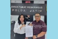 Adinda Wulandari didampingi kuasa hukumnya, Dwi Heri Mustika, Kamis (22/12/2022) tunjukkan surat tanda terima pengaduan di Ditreskrimsus Polda Jatim (Foto : yw)