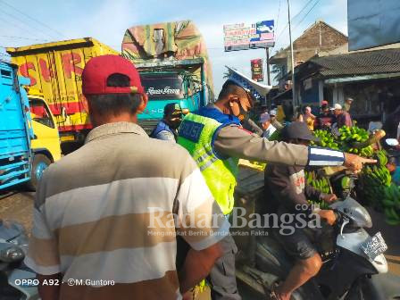 Ket Foto: Anggota Satlantas Polres Lumajang, Aiptu. Guntoro saat mengatur arus lalu lintas di pasar Wates wetan.