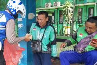 Anggota Kasatlantas Sidoarjo saat berbagi di sekitar lingkunan taman pinang .Selasa ( 17/1/2023) (Foto: Rino Tutuko)