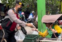 Anggoata satmapta polresta sidoarjo saat berbagi dengan abah bacek yang
Dijalanan, Rabu (18/1/2023) (Foto : Rino Tutuko )
