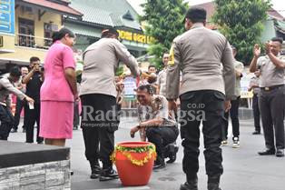 Kapolres Lumajang, AKBP. Dewa Putu Eka Darmawan, S.I.K., M.H, saat menyiram anggota yang naik pangkat, di halaman Mapolres Lumajang, Senin (2/1/2023) (Dok Humas Polres Lumajang)