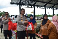 Kapolresta Sidoarjo Kombes Pol. Kusumo Wahyu Bintoro saat bagikan berupa 200 paket sembako pada warga Desa Tlocor, Jabon. Minggu (01/01). (Dok Polresta Sidoarjo)