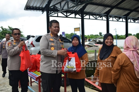 Kapolresta Sidoarjo Kombes Pol. Kusumo Wahyu Bintoro saat bagikan berupa 200 paket sembako pada warga Desa Tlocor, Jabon. Minggu (01/01). (Dok Polresta Sidoarjo)