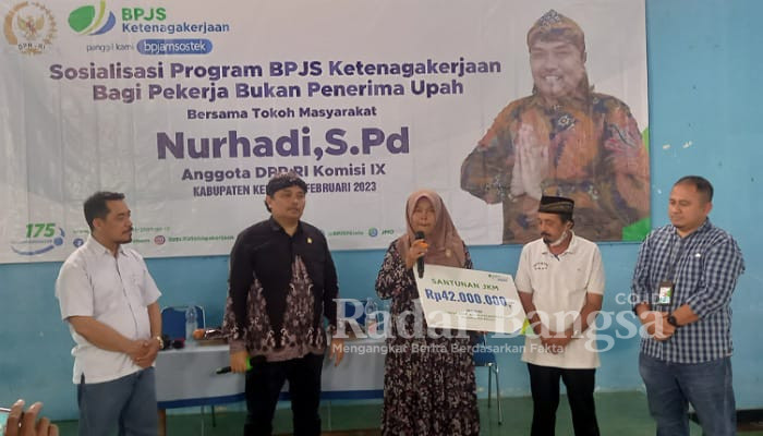 Nurhadi, S.Pd, Anggota Komisi IX DPR RI secara simbolis menyerahkan santunan kematian kepada ahli waris salah satu peserta BPJS Ketenagakerjaan di Desa Pelas (foto: Rurin)