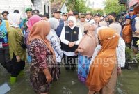 Gubernur Jawa Timur Khofifah Indarparawansa didampingi Bupati Lamongan Yuhronur Efendi saat meninjau  korban terdampak banjir Bengawan Jero di Desa Sidomulyo, Deket Lamongan, Jumat (24/2). (Dok foto pemkab Lamongan for RadarBangsa.co.id)
