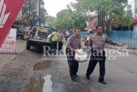 Anggota polsek sedati ikut peduli jalan berlubang ,Kamis (9/2) di jalan raya Sedati (Foto: Rino Tutuko)