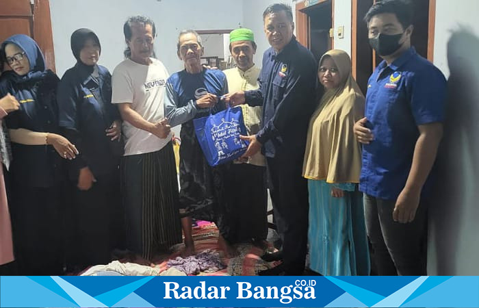 Antox Prapungka Jaya, SE., MM didampingi Kader Partai NasDem dan Kades Bakalan saat memberikan bantuan kepada korban banjir di Dusun Bakalan Kidul (foto: Rurin)