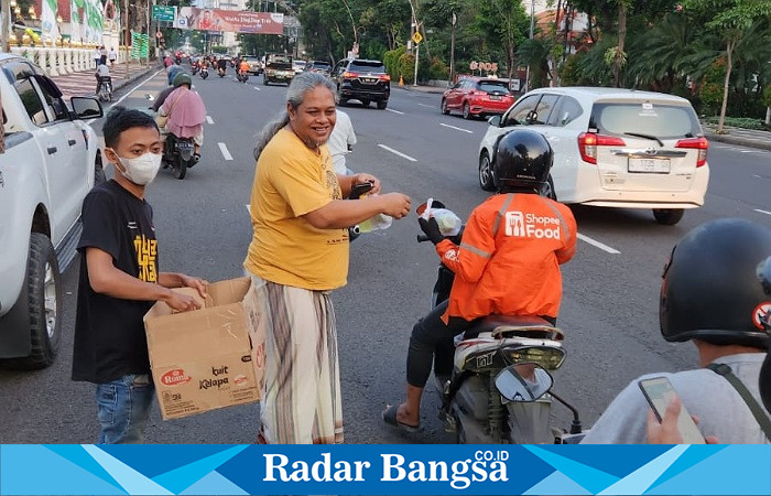 Heru Satriyo (baju kuning) dan Anggota MAKI Jatim membagikan takjil kepada pengguna jalan di depan Gedung Negara Grahadi, Kamis (20/4/2023) sore (Foto : Dok pribadi Heru Satriyo)