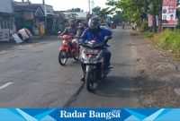 Situasi jalan provinsi di wilayah Desa Tukum, Pengendara terlihat memegangi pinggangnya, Sabtu (10/6). (Dok Riyaman/Radarbangsa.co.id).