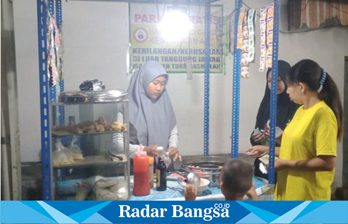  Fitri Ayu Kumala Sari saat melayani pembelinya, Rabu (14/6) malam. (Dok Riyaman/Radarbangsa.co.id)