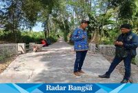 Kepala Desa Sumbersuko berbaju batik, ketika dikonfirmasi di lokasi pembangunan rabat beton, Senin (17/7). (Dok Riyaman/ Radarbangsa.co.id)