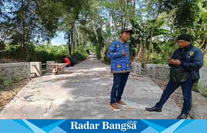 Kepala Desa Sumbersuko berbaju batik, ketika dikonfirmasi di lokasi pembangunan rabat beton, Senin (17/7). (Dok Riyaman/ Radarbangsa.co.id)