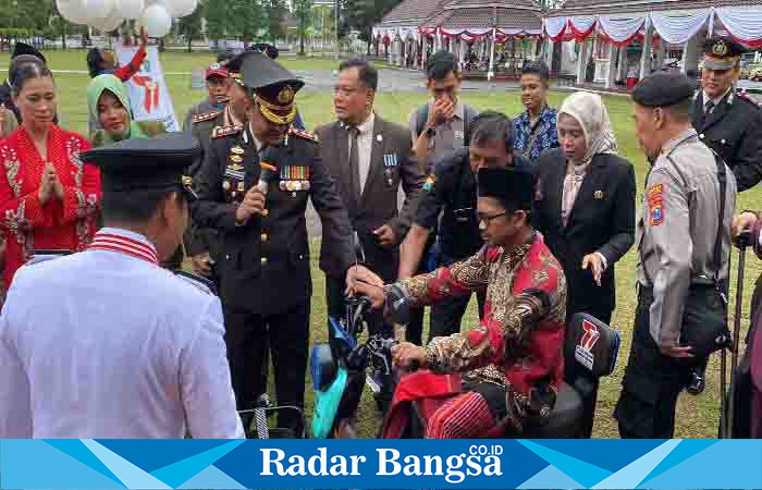 Kapolres Lumajang, AKBP. Boy Jeckson Situmorang, S.H., S.I.K., M.H, ketika menyerahkan sepeda motor listrik roda 3 kepada Seorang Pria penyandang disabilitas, di Alun alun Lumajang, Sabtu (1/7). (Dok Humas Polres Lmj, for Riyaman).