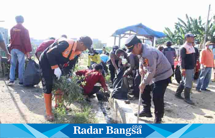 Saat sejumlah anggota polres Pringsewu bersih bersih di Pasar Sarinongko, Kamis 13/07/2023.(dok.Hms/Darmawan/Radar Bangsa)