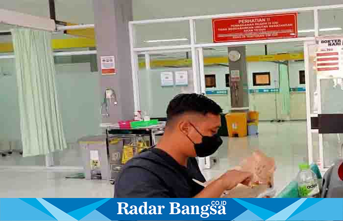  Nugroho (Suami pasien) saat menyuapi istrinya di ruang IGD RSUD dr. Haryoto Lumajang, Minggu (13/8). (Dok Riyaman/Radarbangsa.co.id)