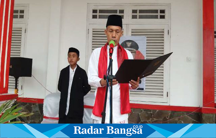 Camat Cidaun H. Koswara. S. Pd, M. Pd didampingi salah seorang santri sedang membacakan tek pidato bupati Cianjur H. Herman Suherman saat memimpin upacara memperingati Hari Santri Nasional (HSN) Tahun 2023. (Dok photo RadarBangsa.co.id/AE Nasution)