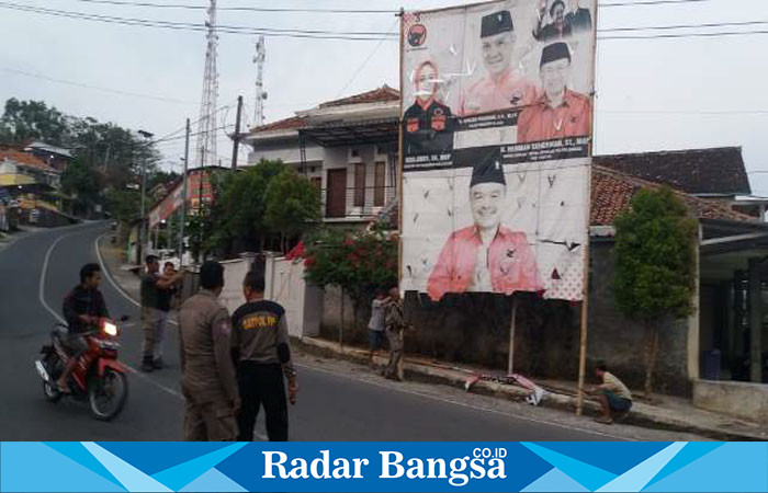 Satuan polisi pamong praja (Satpol PP) Cidaun dibawah komando Kasi Trantib baru Kusnadi sedang menurunkan Alat Peraga Sosial APS/Alat Peraga Kampanye salah satu partai di pertigaan jalan Cidaun. (Dok photo RadarBangsa.co.id/AE Nasution)