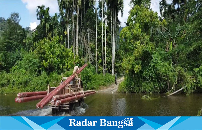 Petugas PLN membawa material pendukung kelistrikan menembus sungai ke Desa Gunung Menasaha, Kecamatan Setia Bakti, Kabupaten Aceh Jaya, Provinsi Aceh yang jaraknya kurang lebih 200 kilometer dari Banda Aceh.