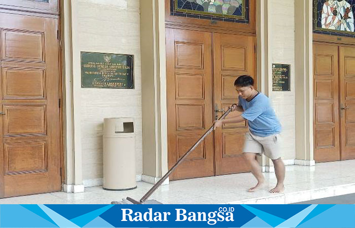 Salah seorang remaja pria umat Paroki KR Surabaya bersemangat mengepel lantai gereja (Foto : FYW)