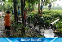 Anggota Koramil 0812/09 Mantup Kodim Lamongan bergotong royong dengan warga membersihkan saluran-saluran sungai di Desa Sukosari. (Dok foto Prayit RadarBangsa.co.id)