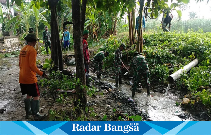 Anggota Koramil 0812/09 Mantup Kodim Lamongan bergotong royong dengan warga membersihkan saluran-saluran sungai di Desa Sukosari. (Dok foto Prayit RadarBangsa.co.id)