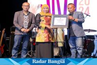 Ketua PWI Jatim, Lutfil Hakim saat memberikan penghargaan PWI Jatim Award sebagai Tokoh Nasional Peduli Ekonomi   kepada Gubernur Jawa Timur, Khofifah Indar Parawansa, dalam acara Prapanca Jazz 2024 (IST)