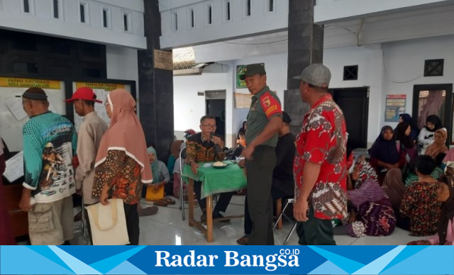 Babinsa Dawuhan Lor Koramil 0821/02 Sukodono, Serka Heri Lesmono, ketika melaksanakan pendampingan penyaluran bantuan paket beras. (Dok istimewa)