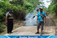 Kepala desa Girimukti Dodi Ahmadi (baju kaos belang-belang) sedang melakulan monitoring pembangunan peningkatan jalan desa dengan aspal lapen oleh UPTD PUPR Wilayah XI Cidaun. (Dok photo RadarBangsa.co.id/AE_Nasution)