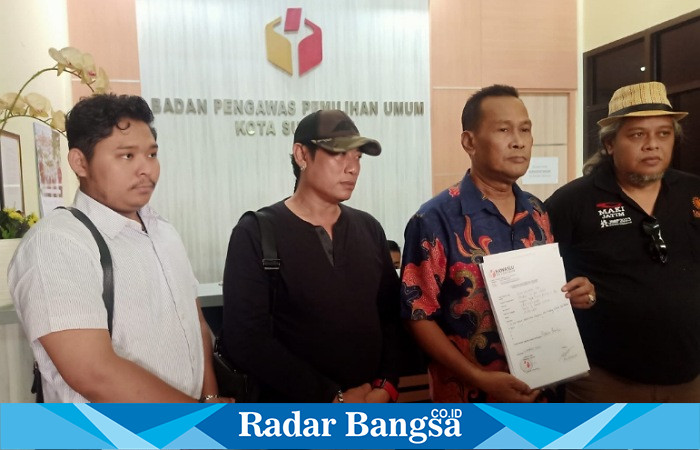 Edy Sucipto (membawa laporan pengaduannya) didampingi Ketua MAKI, Heru Satriyo (paling kanan) seusai menjalani pemeriksaan di kantor Bawaslu Kota Surabaya, Jumat (23/3/2024) siang (Foto : FYW)