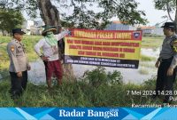 Dua anggota Polsek Tikung saat memasang himbauan di waduk Pule (IST)